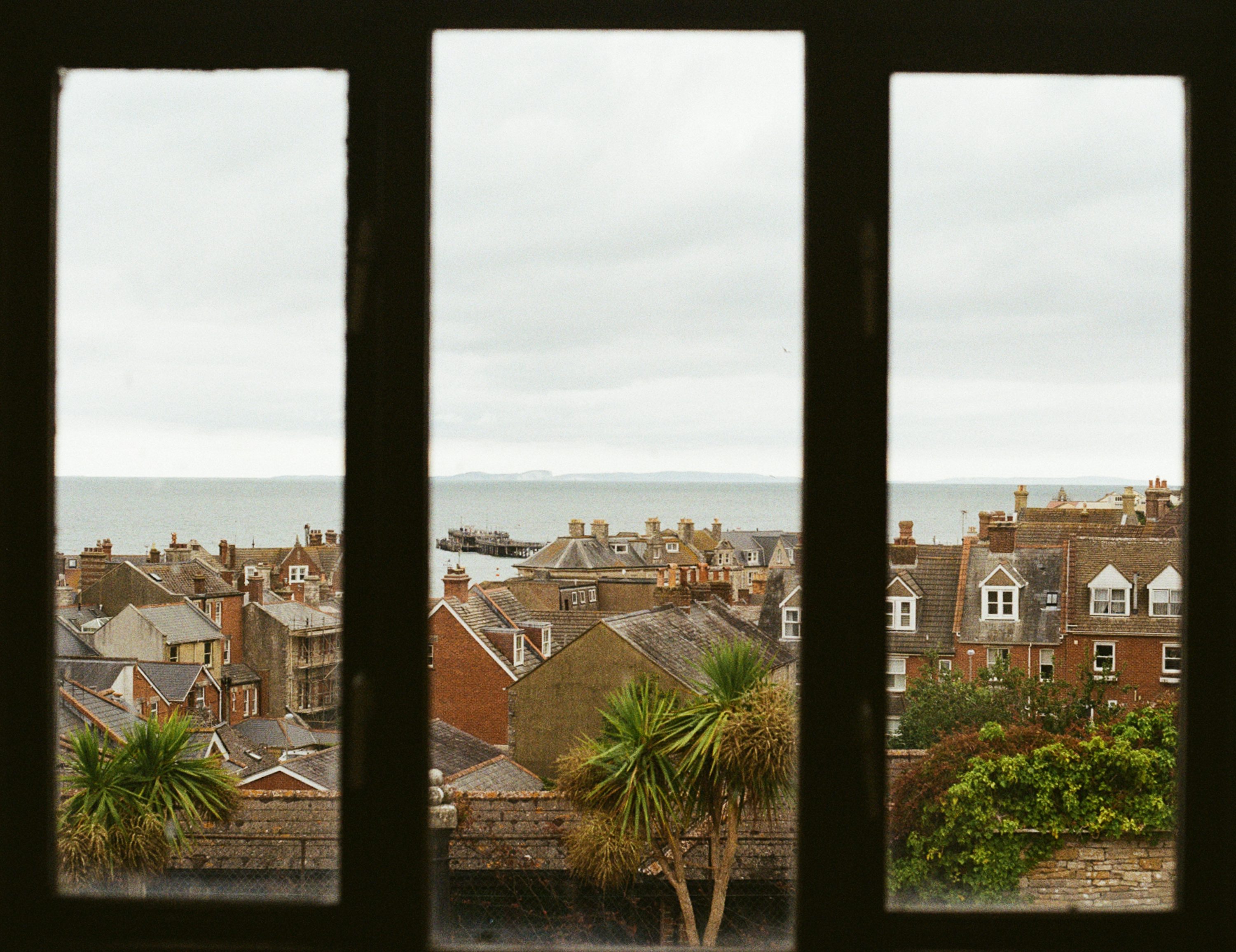 Vue sur les toits de la ville côtière et la mer à travers la fenêtre