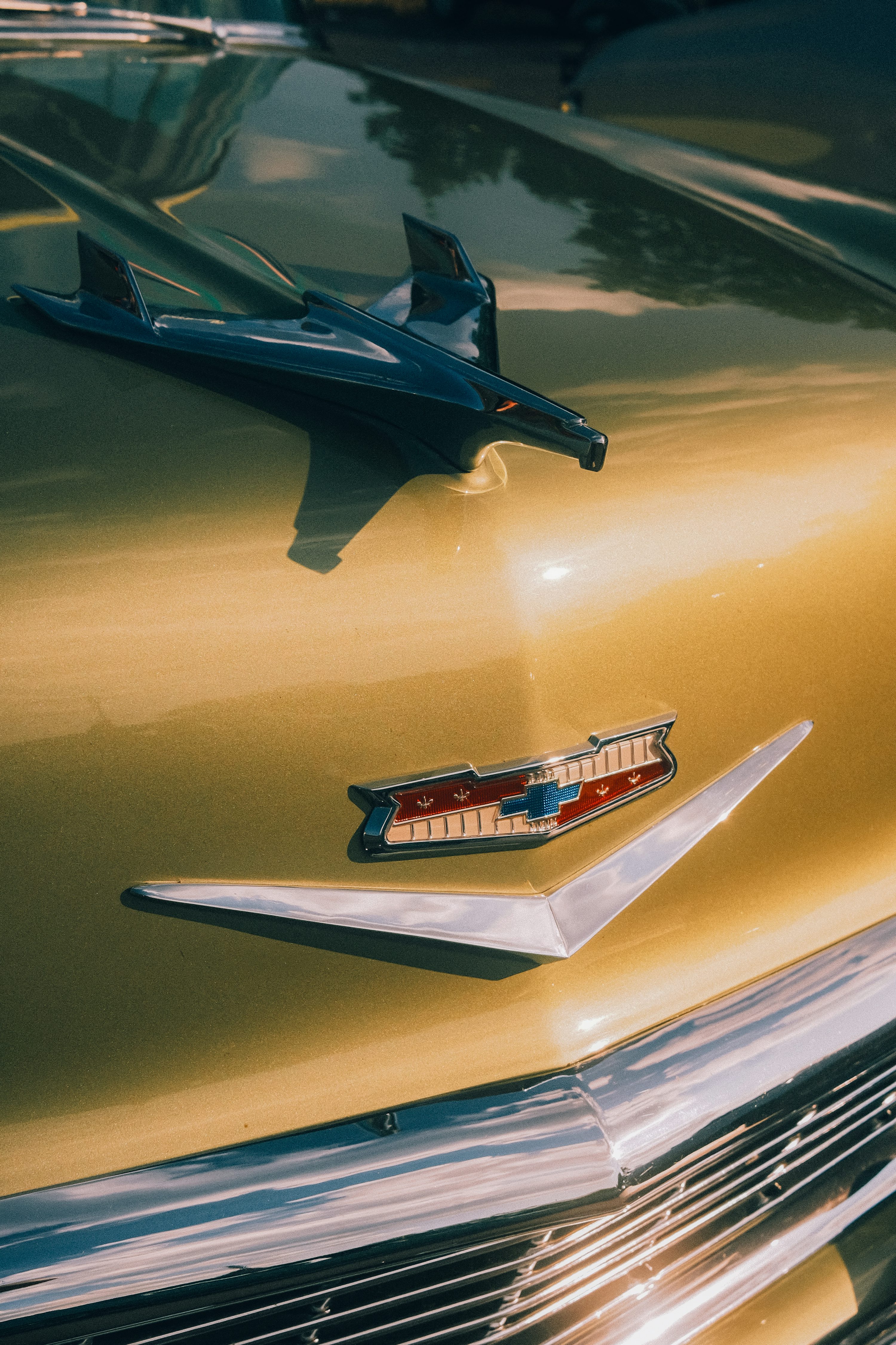 Gros plan d’un capot de voiture ancienne avec des détails chromés.
