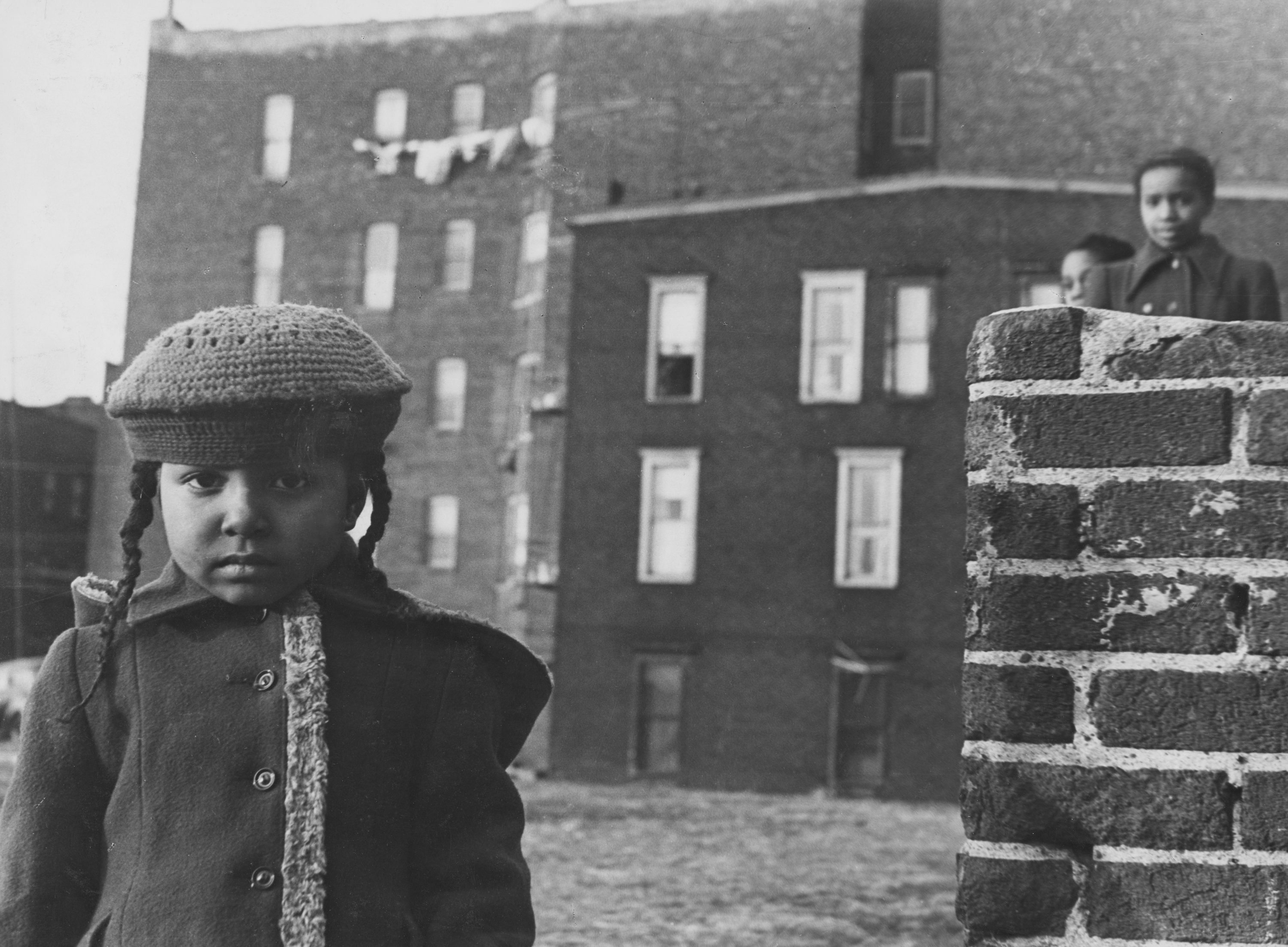 Des enfants devant des bâtiments en brique